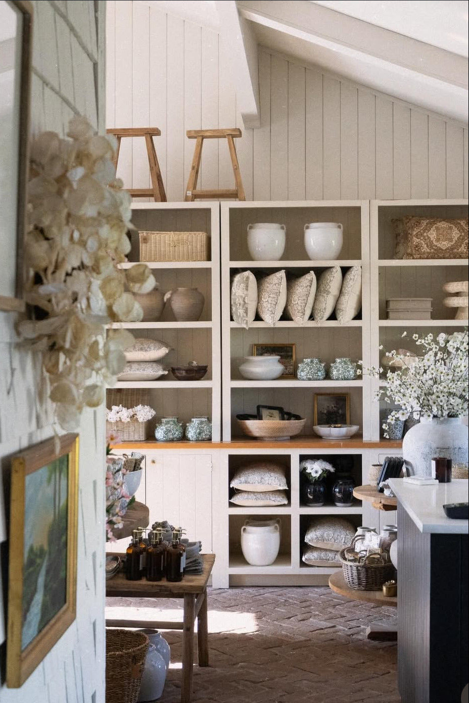 Nautical-themed room with shelves displaying decorative items and framed pictures.